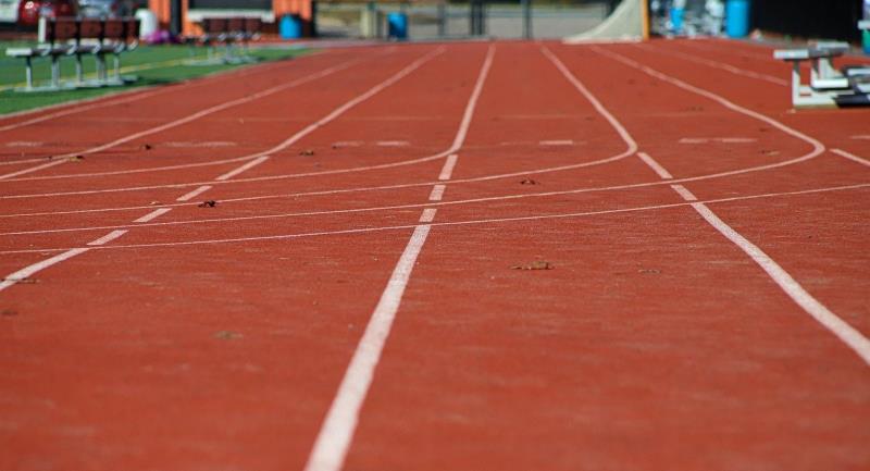 A close-up of an outdoor running track. The viewer is low to the ground, as if they're about to start a race. 